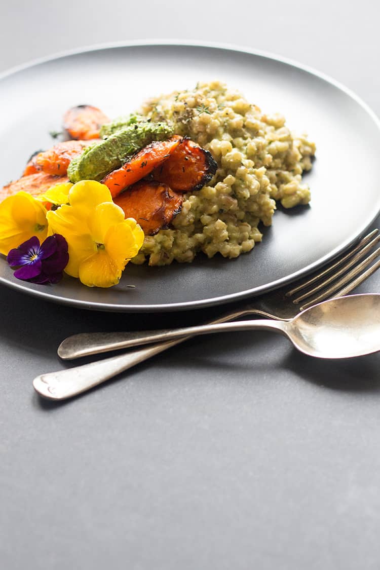 Vegan barley risotto served with maple roasted carrots and kale pesto. 