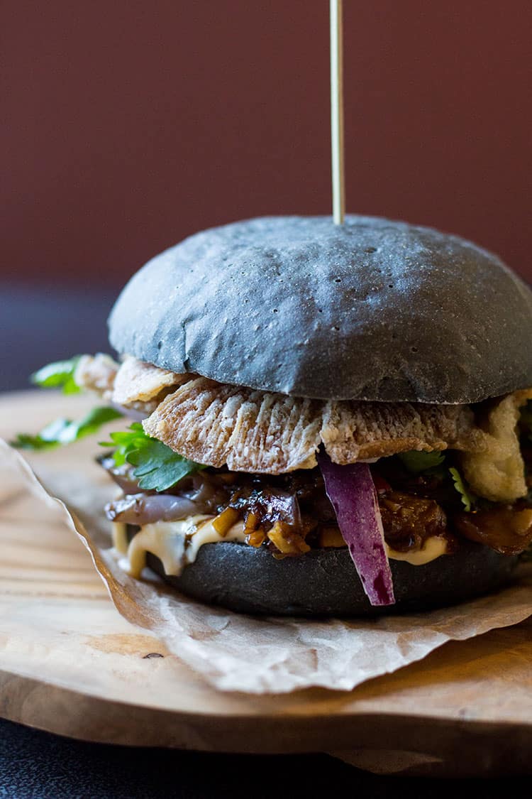 Black burger with crispy oyster mushrooms and spicy eggplant (vegan). 