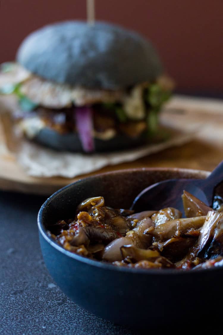 Black burger with crispy oyster mushrooms and spicy eggplant (vegan).