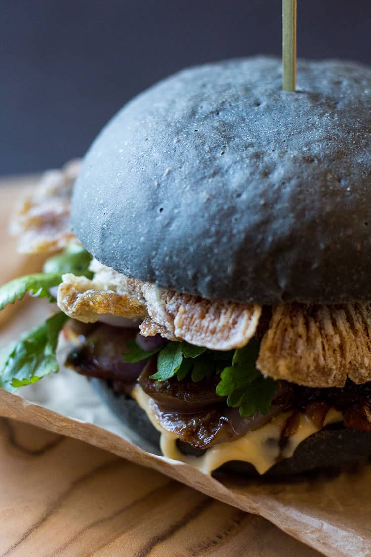 Black burger with crispy oyster mushrooms and spicy eggplant (vegan).