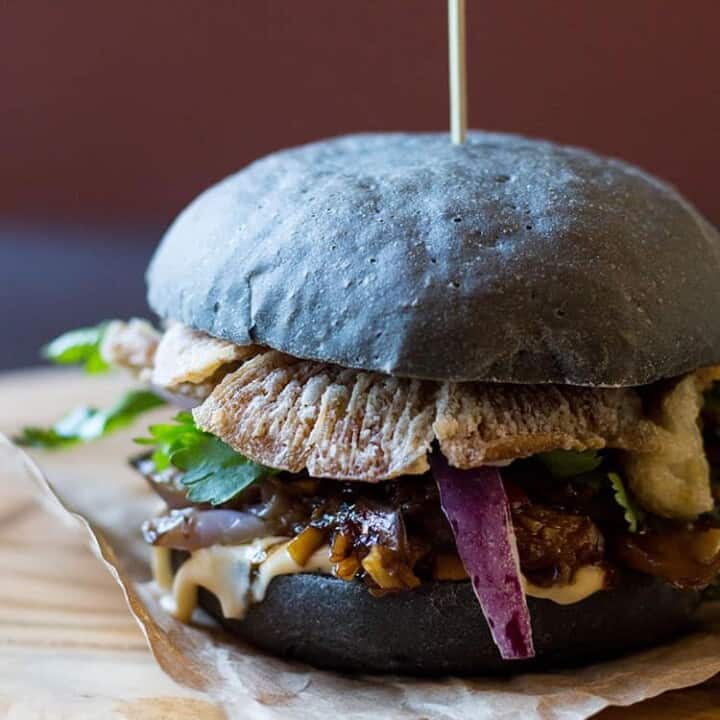 Black burger with crispy oyster mushrooms and spicy eggplant (vegan).