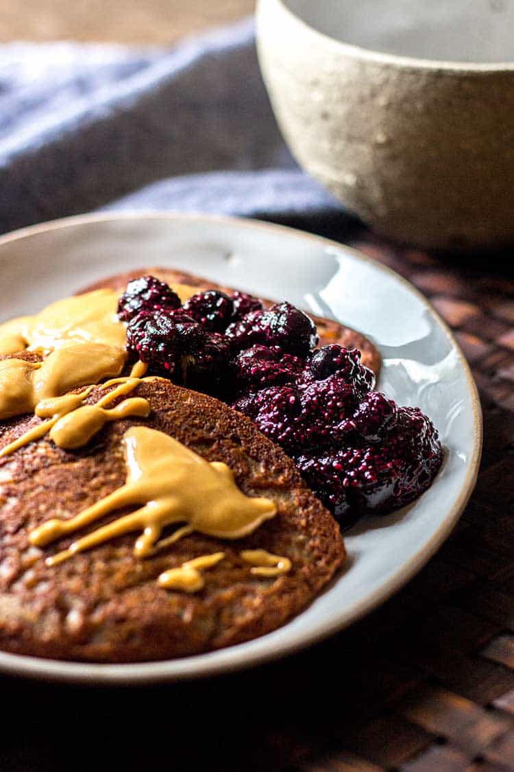 Photo of buckwheat pikelets topped with peanut butter and blueberry chia jam (vegan and gluten free). 