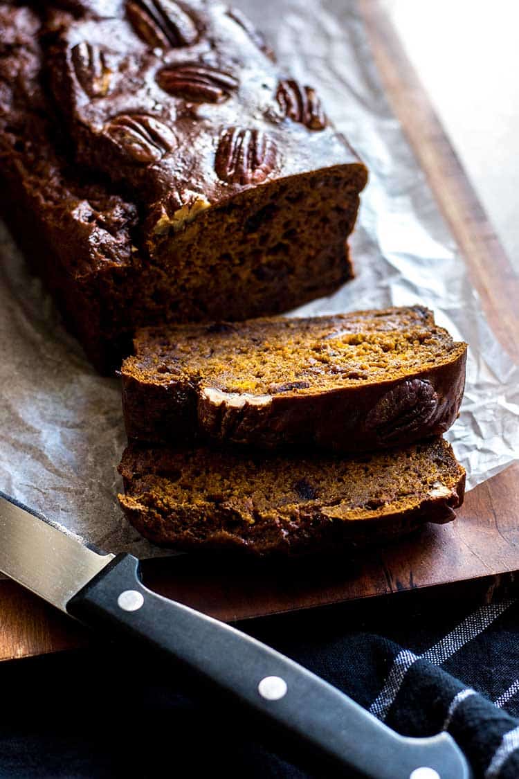 Spiced pumpkin and date loaf, pictured on a chopping board, sliced and ready to eat. (Vegan and refined sugar free). 