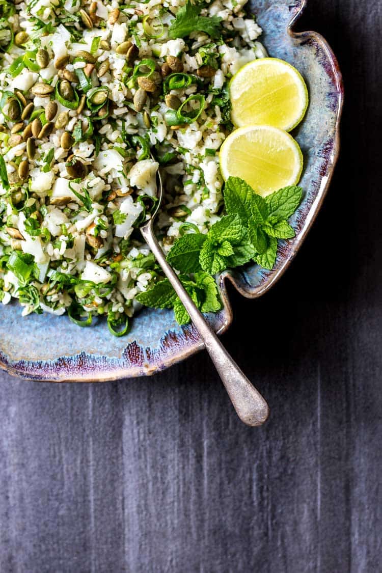 Overhead shot of cauliflower salad with lime and herbs, in a thrift store salad bowl. 