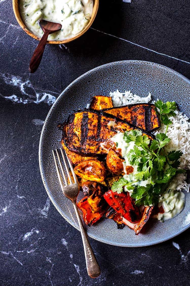 Barbecue grilled curry vegetables served with basmati rice, a spoonful of coconut raita and some fresh coriander (cilantro). A delicious vegan and gluten free summer meal. 