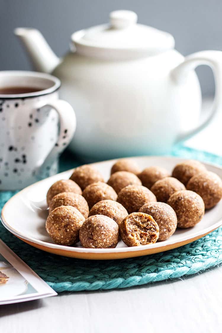 Hot cross bun bliss balls for Easter, pictured with a pot of tea (vegan and gluten free). 