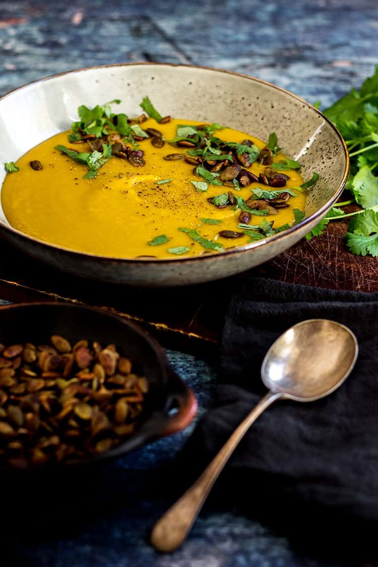 Sweet potato soup with tamari pumpkin seeds (vegan and gluten free). Pictured with a sprinkle of coriander (cilantro) leaves and ready to eat. 