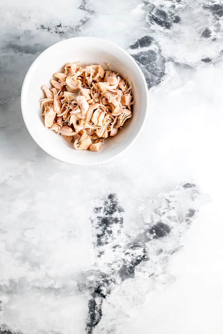 Shredded unripe jackfruit in a white bowl.