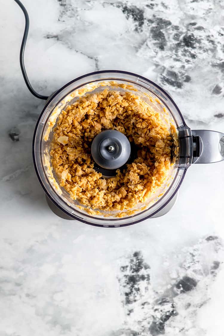 Chickpeas in a food processor, processed to a rough texture. 