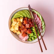 A bowl with edamame beans, sliced radish, cucumber and avocado, fried tofu and marinated watermelon visible.